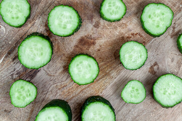 green cucumber cut into slices on a board