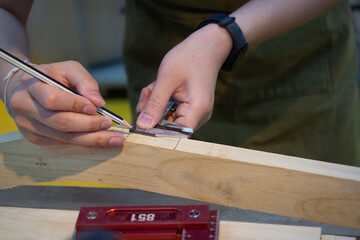 Carpenter working on woodworking on workbench in carpentry shop.