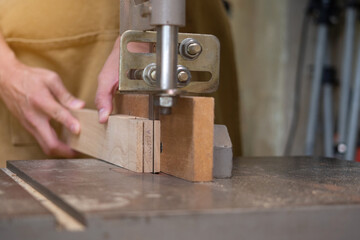 Close up of unknown carpenter working with an electric jigsaw cutting wood. Carpenter concept.