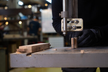 Close up on hand of carpenter at work. Carpenter working with an electric jigsaw cutting wood.