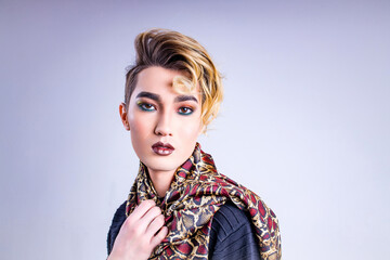 Closeup portrait of a young man with a lipstick over white background