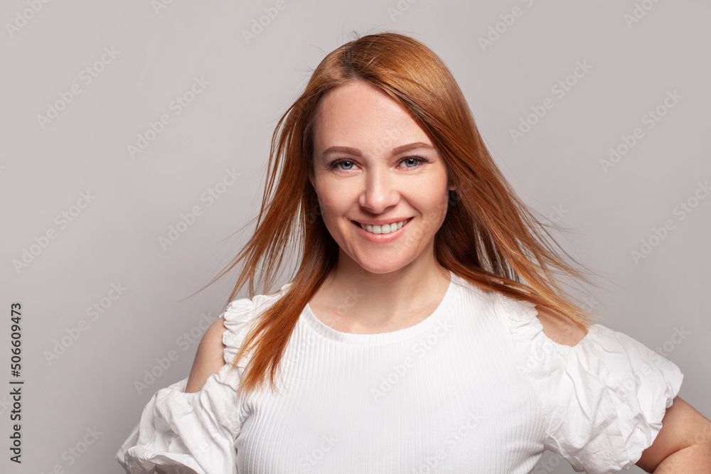 Wall mural positive woman redhead fashion model with long smooth wind blowing red hairstyle