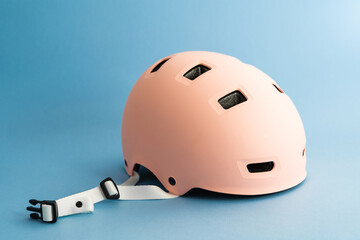 Pink helmet on blue background. Childs outdoors activity safety protection 