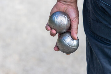 mains qui tient deux boules de pétanque