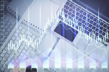 Financial market graph and top view computer on the desktop background. Multi exposure. Investment concept.