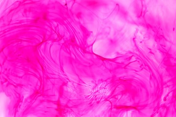 Shallow depth of field shot of swirling pink and blue ink in water - soft flowing abstract and soothing backdrop