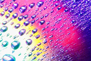 Colorful and vibrant water drops reflecting off of a Digital disc surface - rainbow-colored reflections and light play
