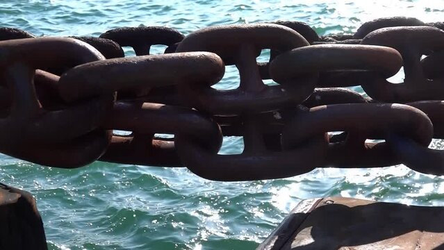 Big iron chain of watercraft. Rusty chain tied to ship pier. POV. Actual camera, close up. Bollard with heavy chain. Strong relationship, solid bonds, reliability concept.