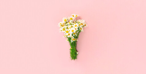 Close up bouquet of wildflowers flowers on pink background, flat lay, top view