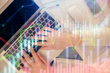 Double exposure of woman hands working on computer and forex chart hologram drawing. Top View. Financial analysis concept.