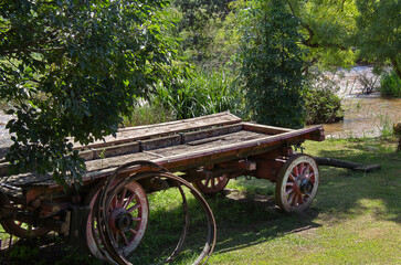 An old wagon next to a stream.