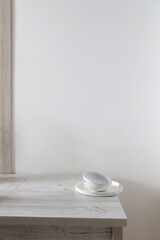 A pyramid of white bowls, plates and cups of different sizes and colors on a beige table in the kitchen. Scandinavian style. Place for your text. Copy space