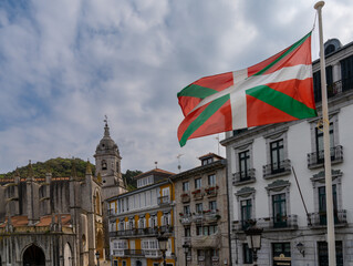 downtown Lekeitio with historic buildings and the Basque Country flag