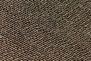 Abstract textured background of corrugated cardboard of beige color. Close-up.