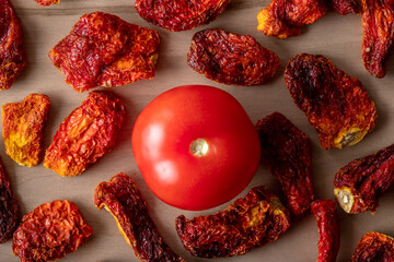 Fresh tomatoes and sun dried tomatoes together on wooden background	