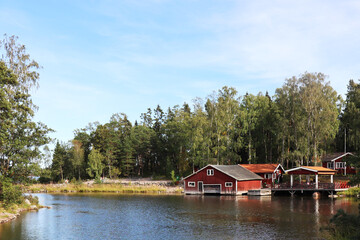 Fototapeta na wymiar landscape view of a typical red swedish house with a lake