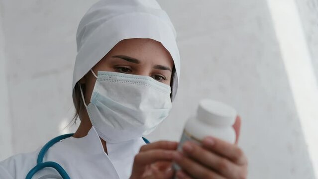 Doctor looking at pack of pills medication. Reads the composition of the pills