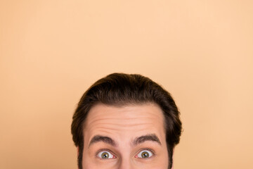 Cropped photo of young excited guy advertising spy look promotion isolated over beige color background