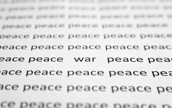 War and peace concept. Close-up of printed text of words Peace and one word War on white paper. Low angle view, selective focus, macro photo