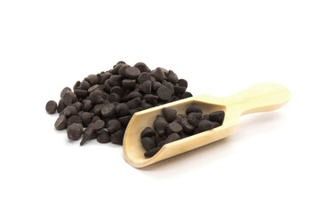 Black chocolate chips morsels in wooden spoon