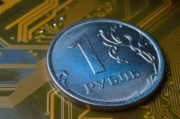 A coin with a face value of 1 ruble lies on a microcircuit. close-up. Translation of the inscription on the coin: "1 ruble" The concept of the digital economy in the Russian Federation