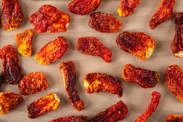 Slices of sun-dried tomatoes on wooden background