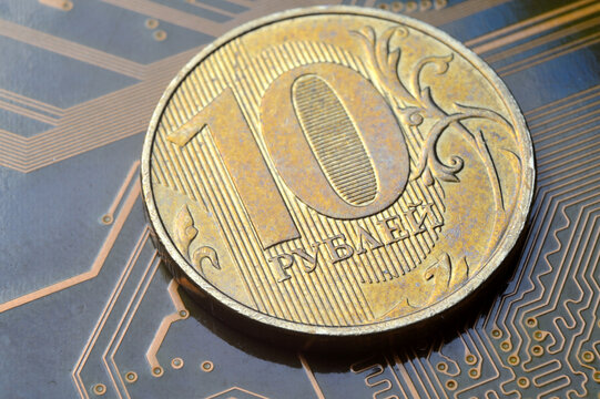 A coin with a face value of 10 rubles lies on a microcircuit. close-up. Translation of the inscription on the coin: "10 rubles" The concept of the digital economy in the Russian Federation