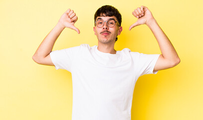 young adult hispanic man feeling proud, arrogant and confident, looking satisfied and successful,...