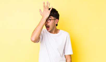 young adult hispanic man raising palm to forehead thinking oops, after making a stupid mistake or...