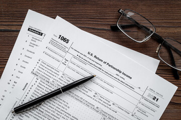 US individual tax form with pen and glasses on businessman table