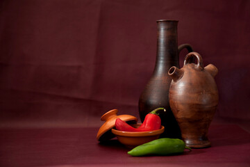 Three old clay pots jars vases and green , red peppers paprika