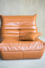 a large orange leather armchair stands on the floor
