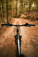 Fototapeta na wymiar Close up of a suspension air fork on a mountain bike. Riding a bicycle in the forest. Concept of having fun while riding outdoors on a cross country bike. Hydraulic suspension absorbs offroad paths