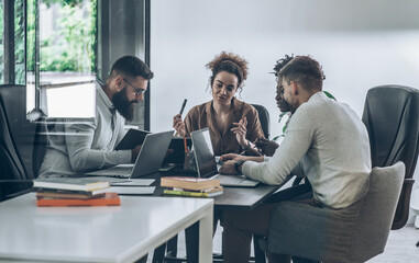 Casually dressed young businesspeople at the office. Discussing ideas for a new startup project.