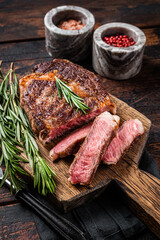 Sliced and Grilled rib eye steak, rib-eye beef marbled meat on a wooden board. Wooden background....