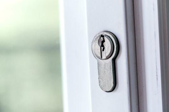 Keyhole close-up. Home security, property protection. Door lock on a white door