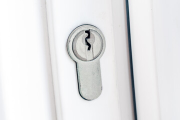 Home security, property protection. Door lock on a white door. Keyhole close-up