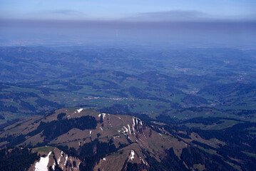 Obraz premium Panoramic landscape with rocks and hills seen from Säntis peak at Alpstein Mountains on a sunny spring day. Photo taken April 19th, 2022, Säntis, Switzerland.