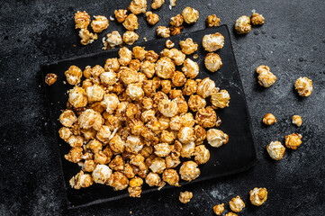 Obraz na płótnie Canvas Homemade Crunchy Caramel Popcorn on marble board. Black background. Top view