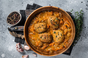 Cutlets or Fish balls with tuna in tomato sauce. Gray background. Top view