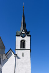Fototapeta na wymiar Protestant church tower at village Urnäsch on a sunny spring day. Photo taken April 19th, 2022, Urnäsch, Canton Appenzell Ausserrhoden, Switzerland.