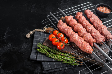 Raw Shish kebab from mince lamb and beef meat, turkish adana kebab on Skewers. Black background. Top view. Copy space