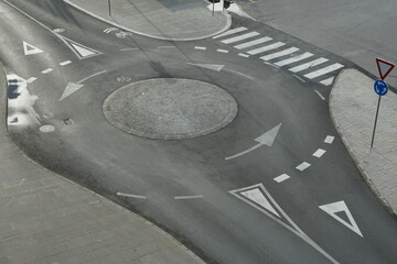 Aerial view from top on empty traffic circle or roundabout road with white arrows, crosswalk and...