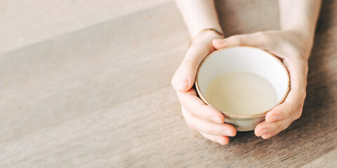 Women's hands hold a cup of tea.