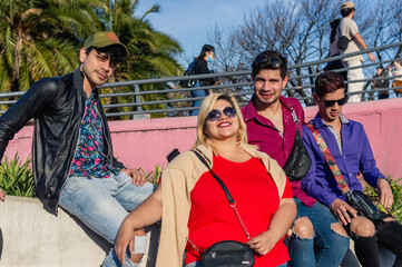 group of young latin caucasian friends outdoors enjoying together looking at the camera.