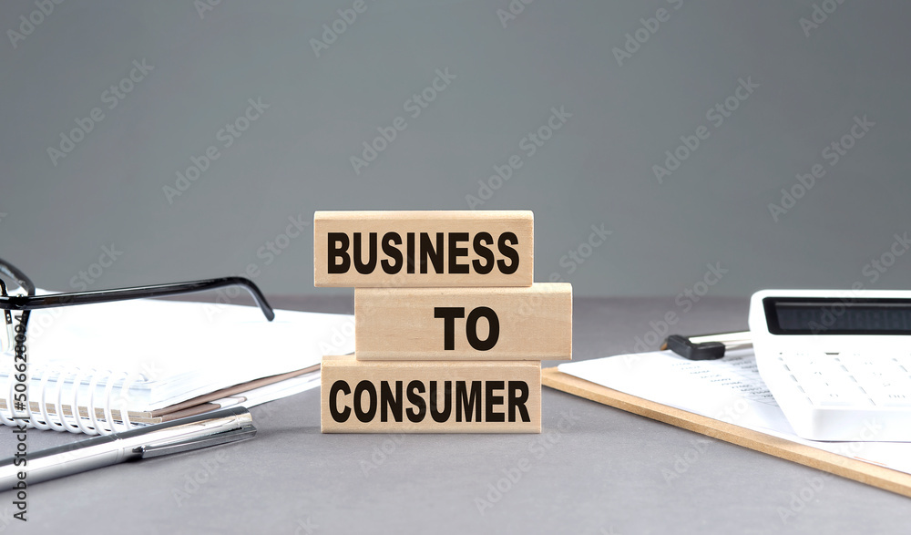 Poster business to consumer text on wooden block with notebook,chart and calculator, grey background
