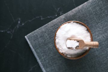 Coarse salt in a bowl on black background 