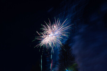 Bright festive salute of yellow-green color, with haze, in the night sky