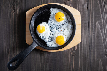 Fried quail eggs in a cast-iron small skillet