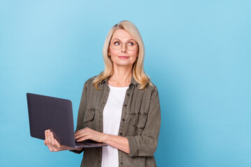 Photo of minded aged lady use netbook type email partners decide what write wear shirt isolated blue color background